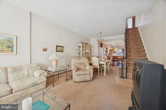 a living room with furniture and a chandelier