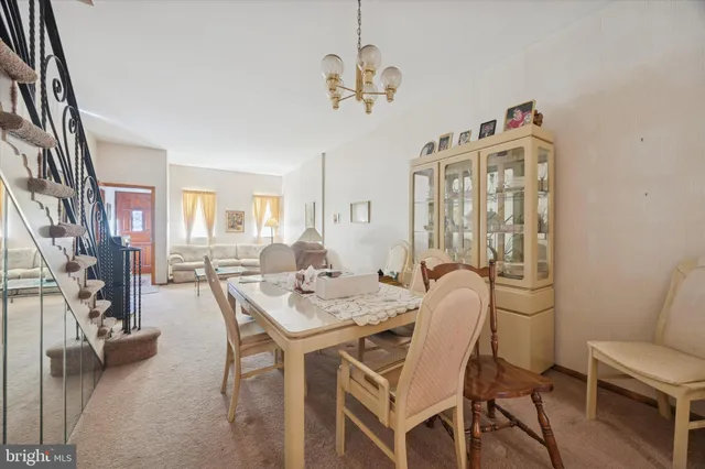 a dining room with furniture a chandelier and wooden floor