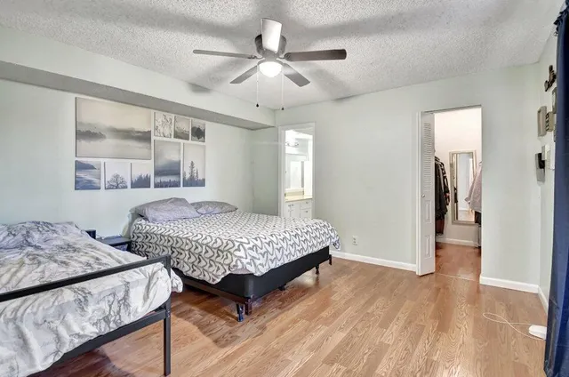 a bedroom with a large bed and a chandelier fan