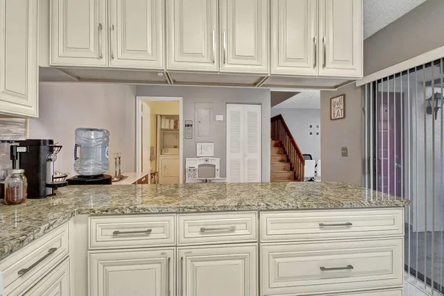 a kitchen with granite countertop stainless steel appliances white cabinets and a sink