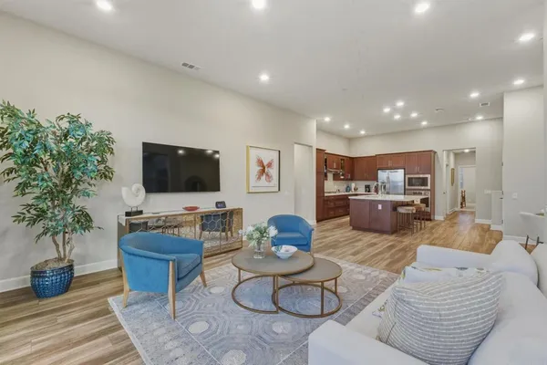 a living room with furniture kitchen view and a flat screen tv