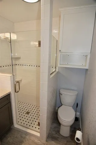 a bathroom with a toilet and a shower