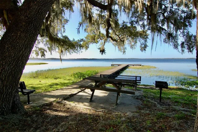 a view of swimming pool with lawn chairs and a yard