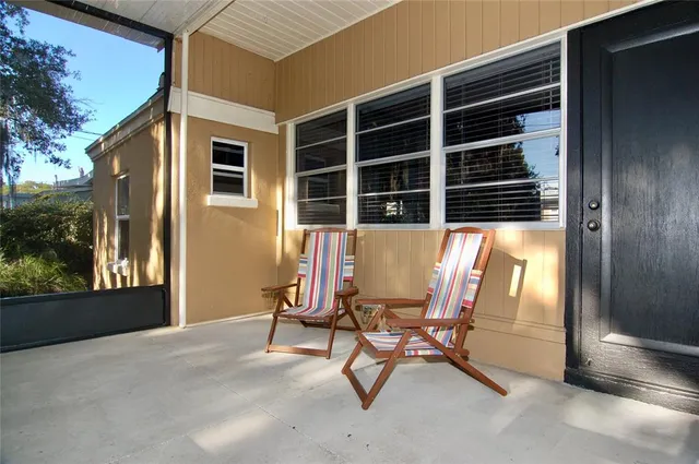 a view of a house with backyard and sitting area