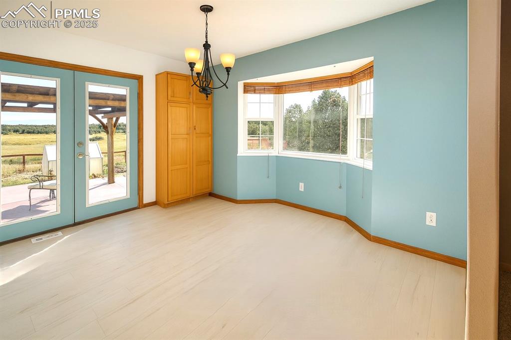 770 Cedar Hills Road Penrose, CO 81240 - Photo 9 of 49 a view of an empty room with a window and chandelier