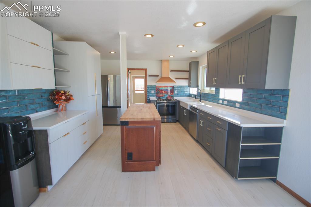 770 Cedar Hills Road Penrose, CO 81240 - Photo 10 of 49 a large white kitchen with stainless steel appliances kitchen island granite countertop a large counter top and white cabinets