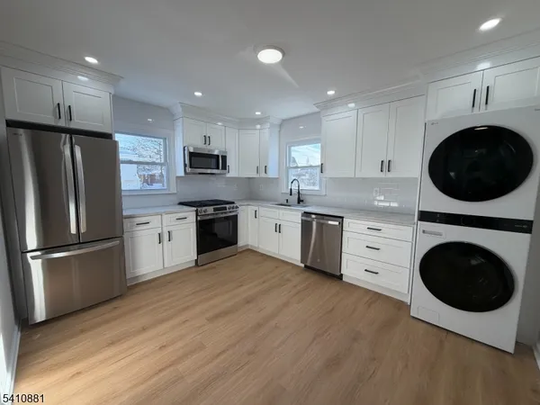 a kitchen with a sink a refrigerator and cabinets