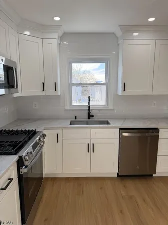 a kitchen with granite countertop white cabinets and white appliances