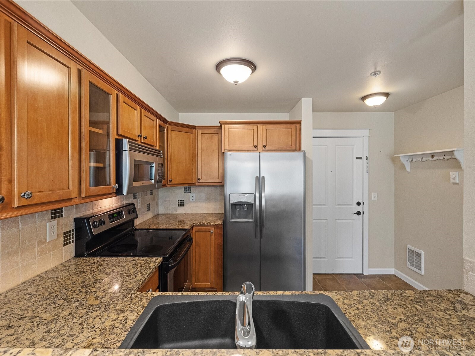 690 32nd Street, Unit B205 Bellingham, WA 98225 - Photo 27 of 40 a kitchen with a sink a refrigerator and cabinets