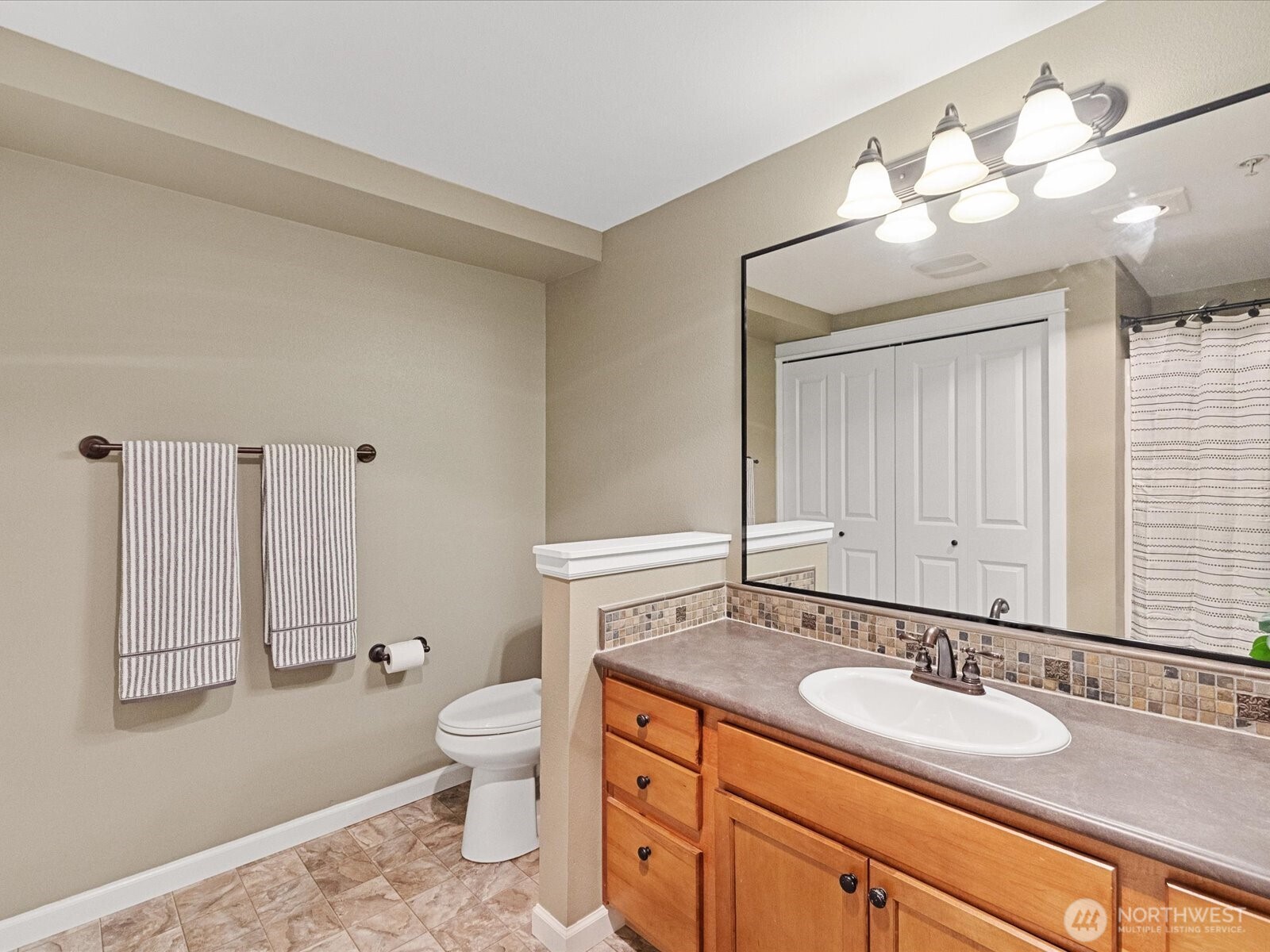 690 32nd Street, Unit B205 Bellingham, WA 98225 - Photo 35 of 40 a bathroom with a granite countertop sink a toilet and a mirror