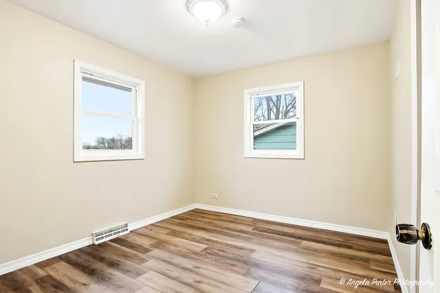 a view of an empty room with wooden floor