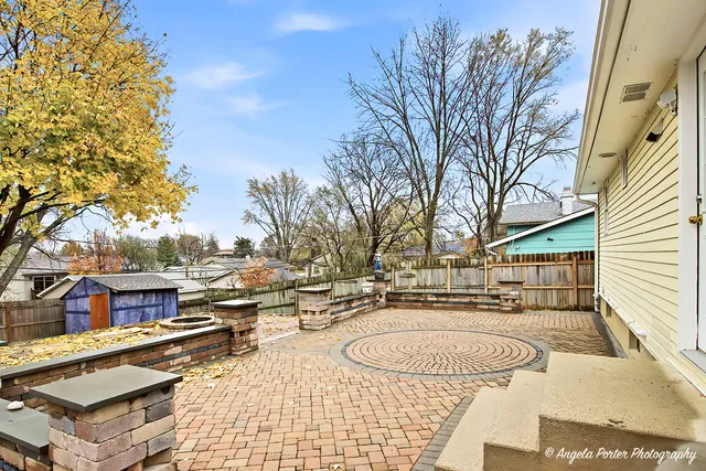 a backyard of a house with wooden fence and large trees