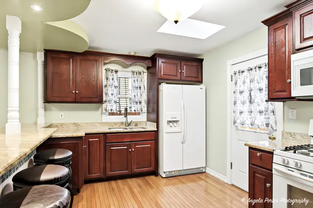 a kitchen with stainless steel appliances granite countertop a refrigerator a sink dishwasher stove and wooden cabinets