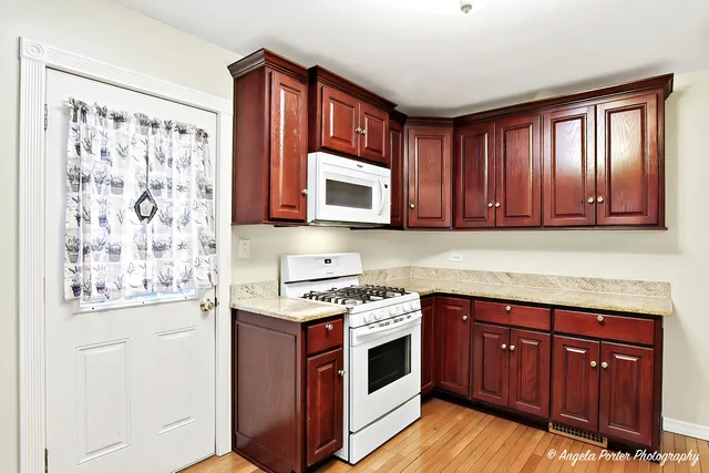 a kitchen with stainless steel appliances wooden cabinets and a stove top oven