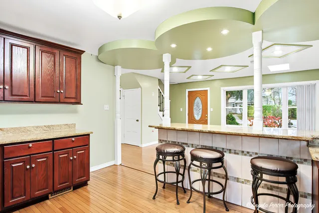a kitchen with stainless steel appliances granite countertop wooden cabinets a dining table and chairs