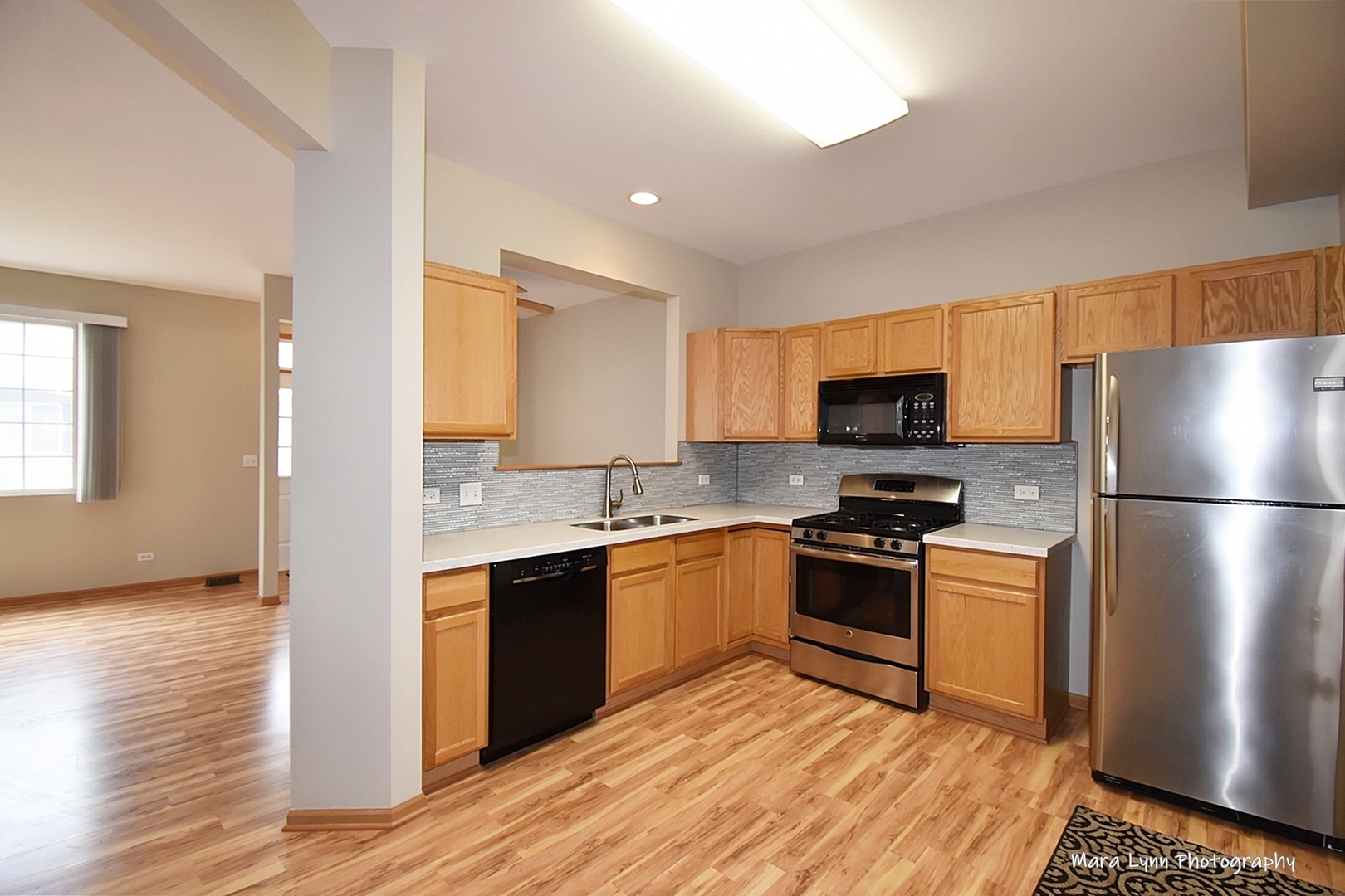 760 County Line Road Aurora, IL 60502 - Photo 4 of 25 a kitchen with stainless steel appliances granite countertop a stove a sink dishwasher a refrigerator and a microwave oven with wooden floor