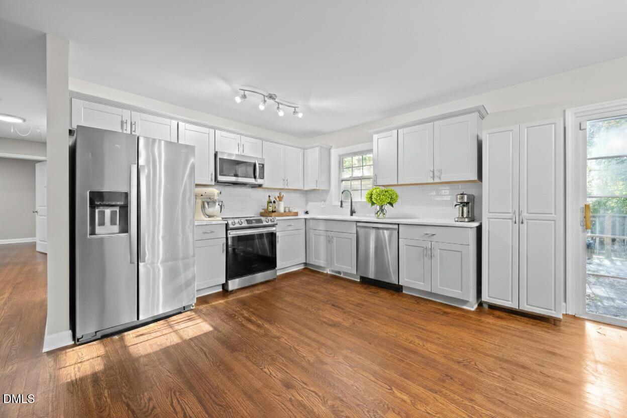 2950 Glenridge Drive Raleigh, NC 27604 - Photo 7 of 53 a kitchen with stainless steel appliances a refrigerator sink and cabinets