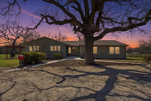 a view of a house with a yard tree and a yard