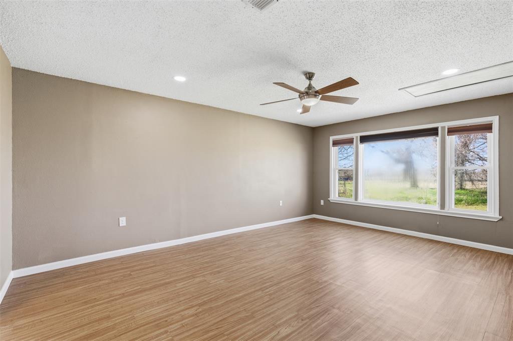 755 County Road 4280 Decatur, TX 76234 - Photo 11 of 36 an empty room with wooden floor and windows