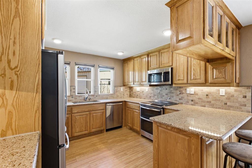 755 County Road 4280 Decatur, TX 76234 - Photo 21 of 36 a kitchen with stainless steel appliances granite countertop a sink and stove top oven