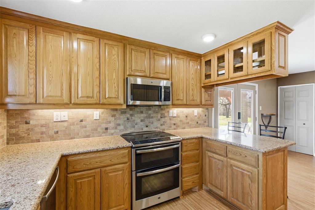 755 County Road 4280 Decatur, TX 76234 - Photo 22 of 36 a kitchen with stainless steel appliances granite countertop a stove microwave and cabinets
