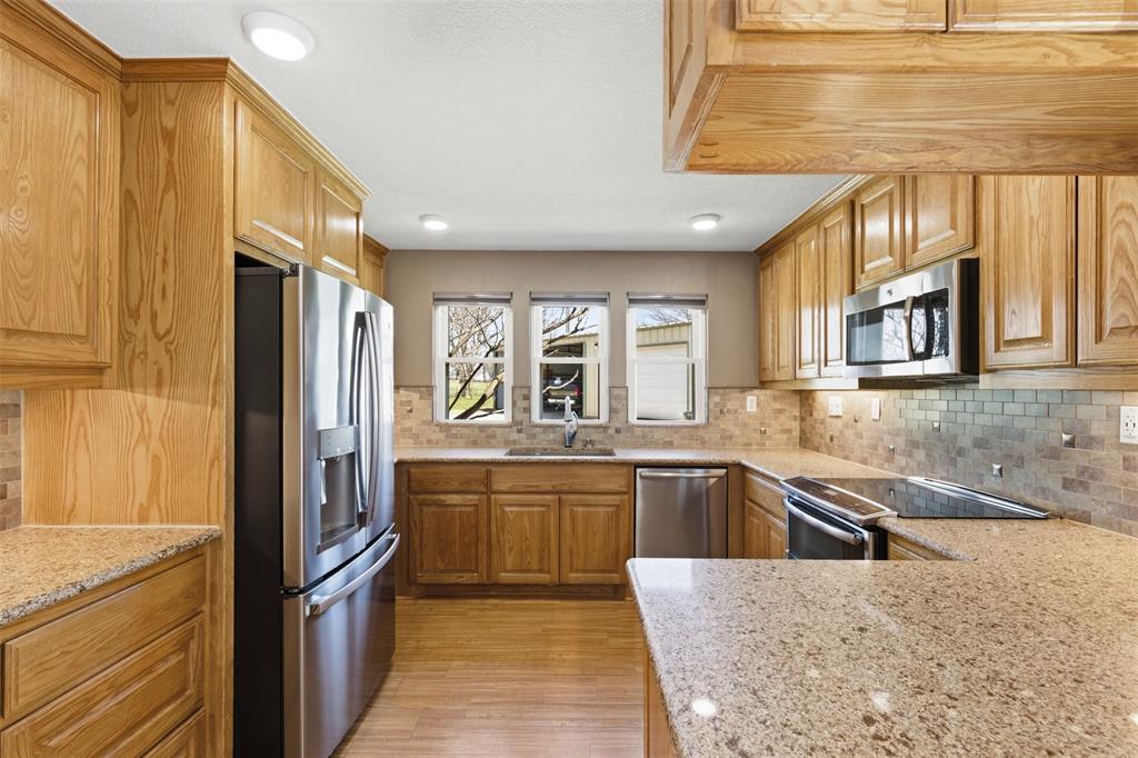 755 County Road 4280 Decatur, TX 76234 - Photo 23 of 36 a large kitchen with granite countertop a sink and stainless steel appliances
