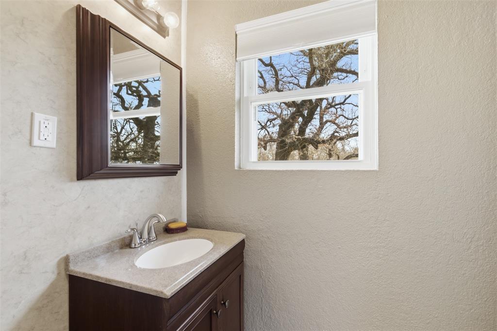 755 County Road 4280 Decatur, TX 76234 - Photo 29 of 36 a bathroom with a sink and a mirror