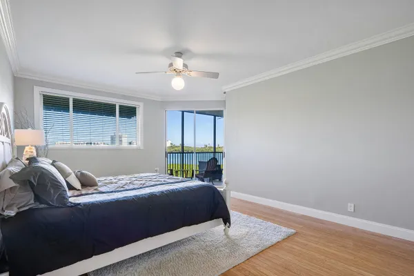 a bedroom with a bed ceiling fan and window