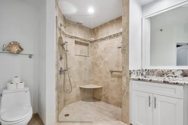 a bathroom with a granite countertop sink toilet and shower