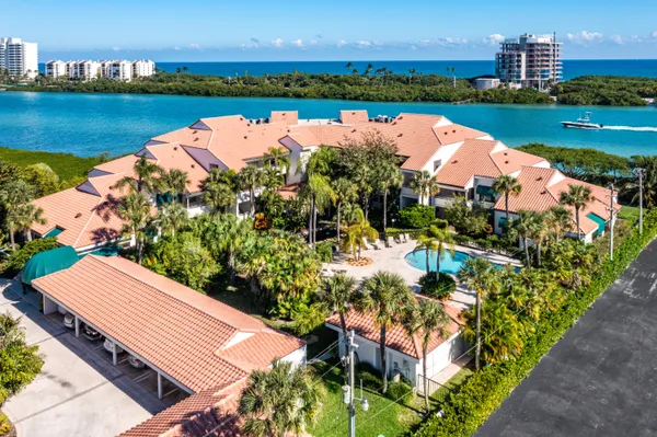 an aerial view of a house with outdoor space lake view and an ocean view