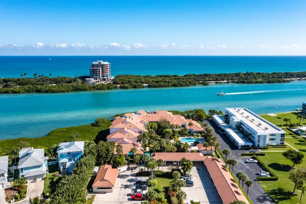 an aerial view of ocean and residential houses with outdoor space