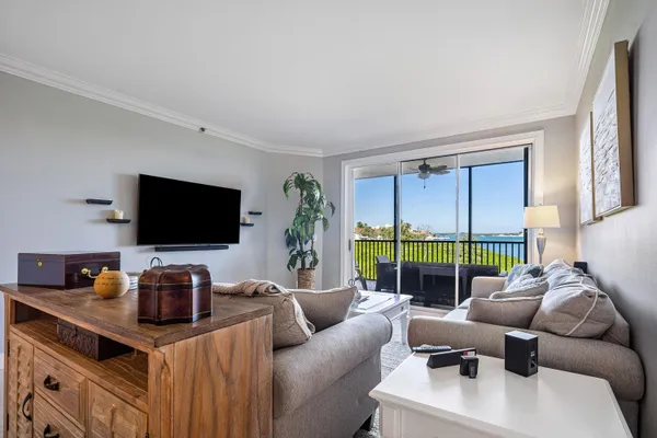 a living room with furniture a flat screen tv and a floor to ceiling window