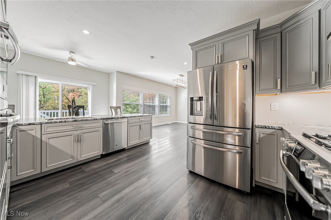 5270 Brainard Road Solon, OH 44139 - Photo 10 of 45 Kitchen with appliances with stainless steel finishes, light stone countertops, gray cabinets, recessed lighting, and dark wood-style flooring