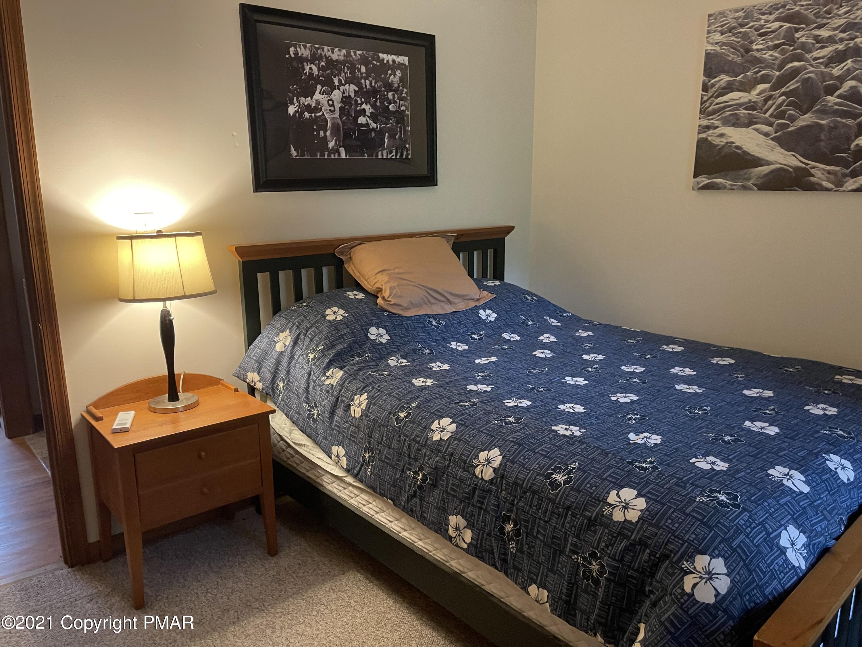 131 Maple Road Blakeslee, PA 18610 - Photo 19 of 35 a bed room with a bed and a lamp