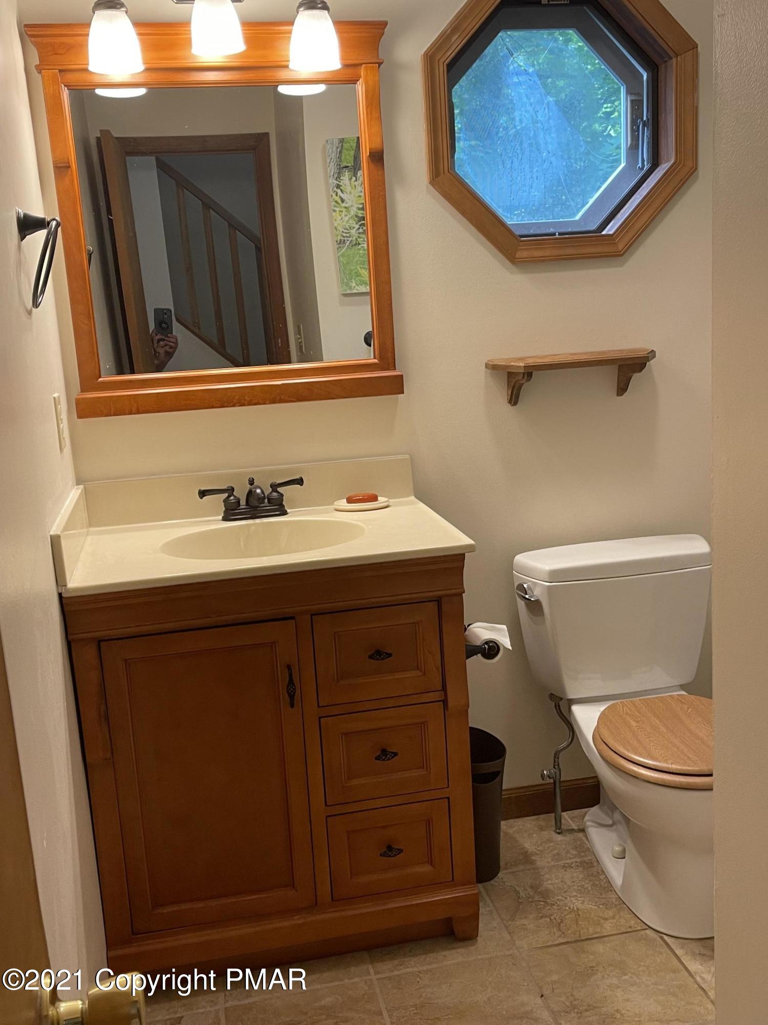 131 Maple Road Blakeslee, PA 18610 - Photo 21 of 35 a bathroom with a toilet a sink and mirror