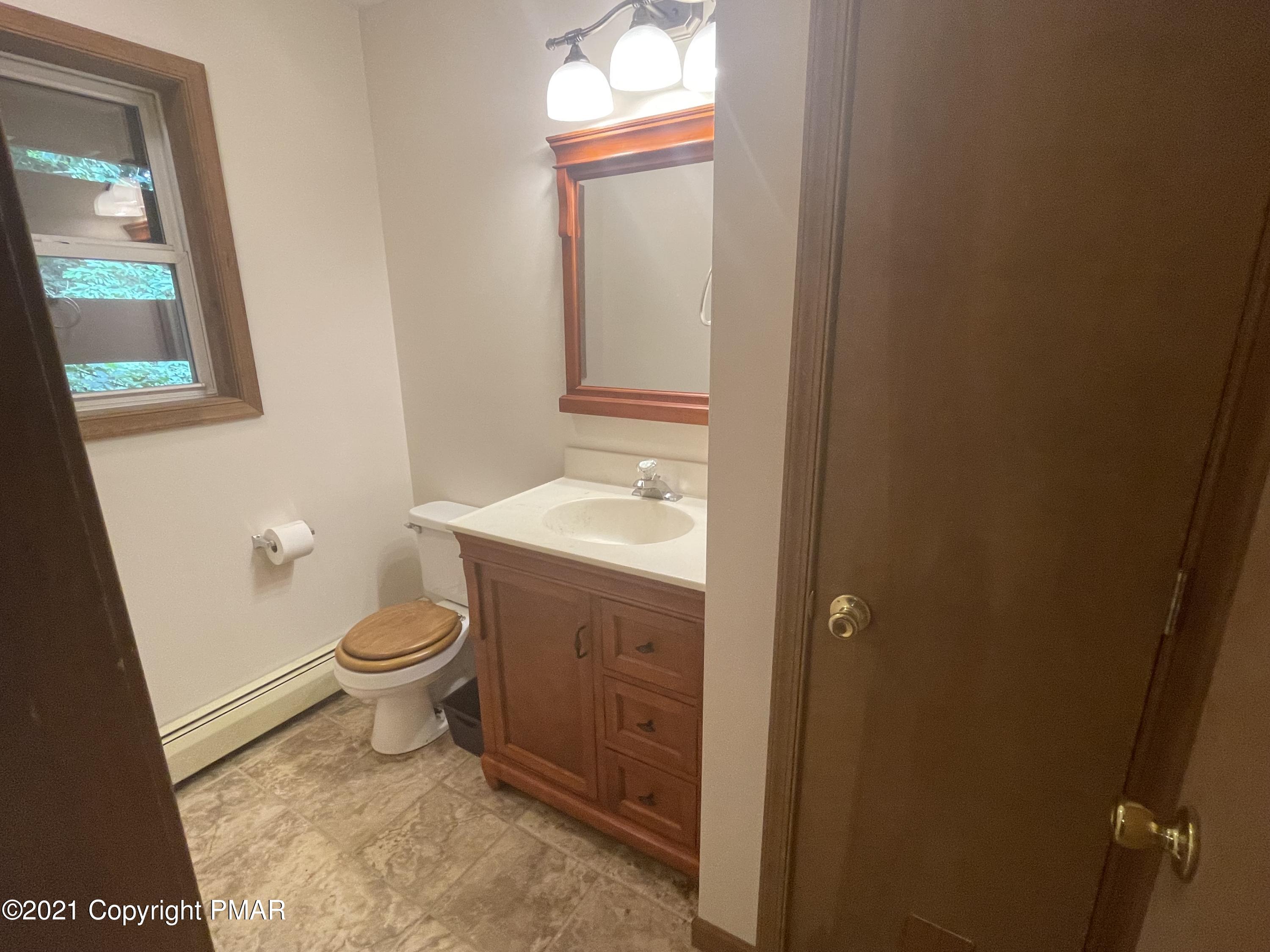 131 Maple Road Blakeslee, PA 18610 - Photo 28 of 35 a bathroom with a toilet a sink a vanity and mirror