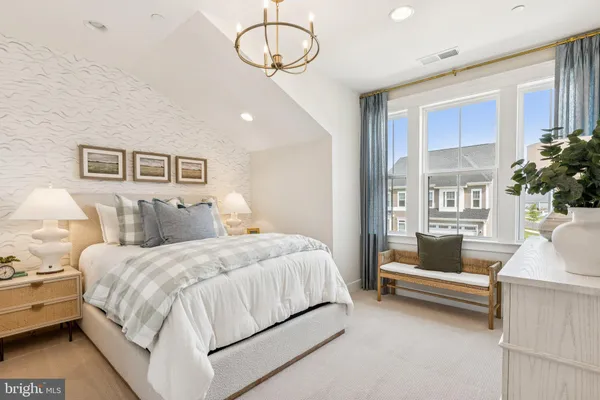 a bedroom with a large bed and a chandelier