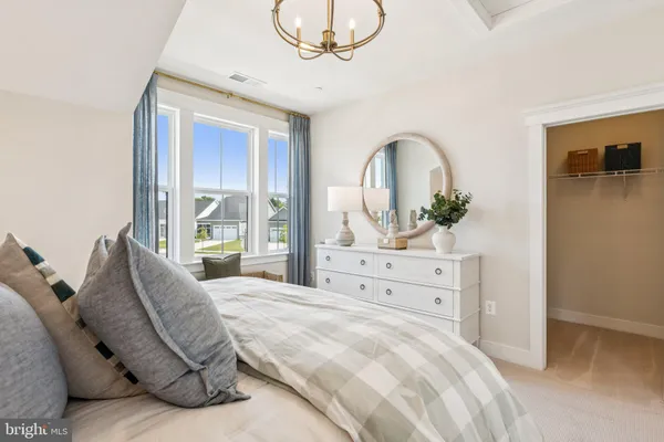 a bedroom with a bed a couches and large windows
