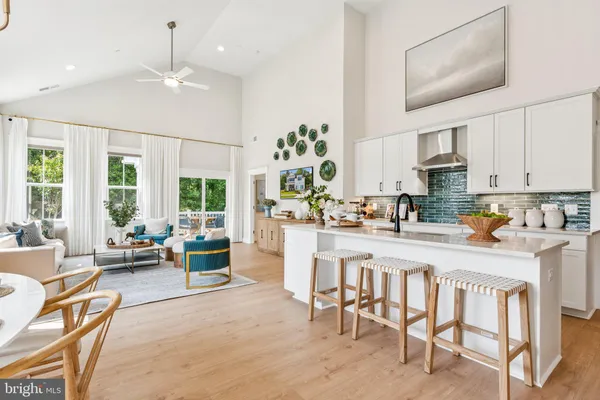 a kitchen with stainless steel appliances granite countertop a stove top oven a sink dishwasher and white cabinets with wooden floor
