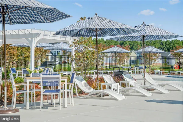 a view of swimming pool with lawn chairs and plants