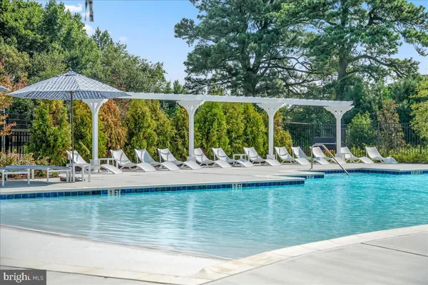 a view of a swimming pool with a table and chairs under an umbrella