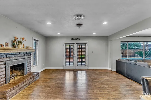 a view of an empty room with a fireplace and a window