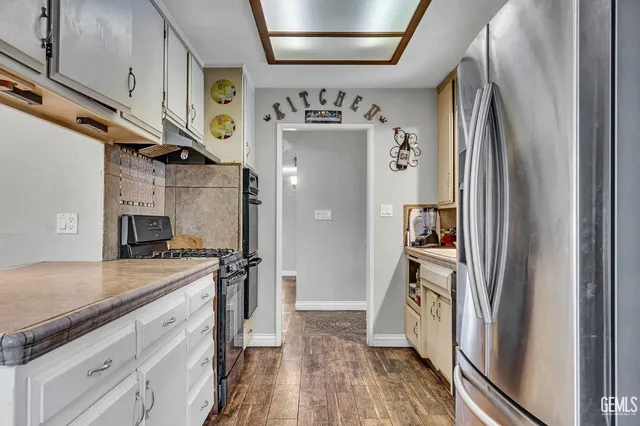 a kitchen with granite countertop a refrigerator and a sink