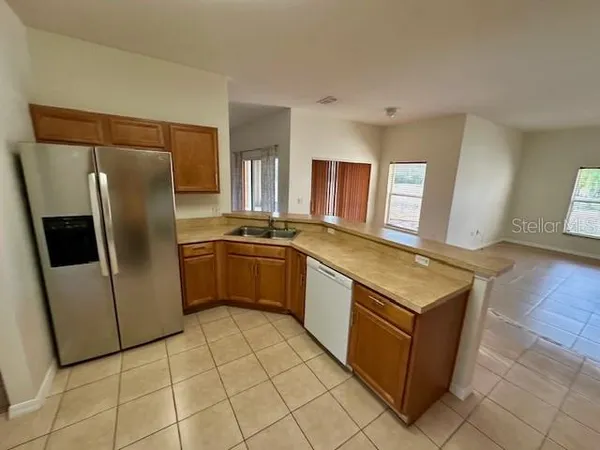 a kitchen with stainless steel appliances a refrigerator sink and microwave