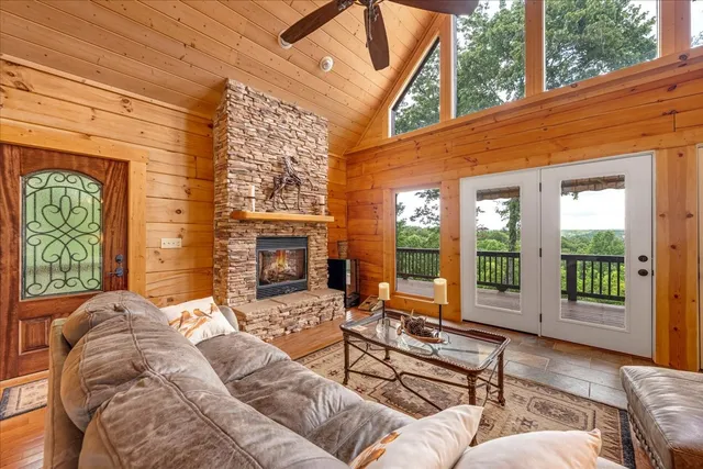 a living room with furniture large windows and wooden floor
