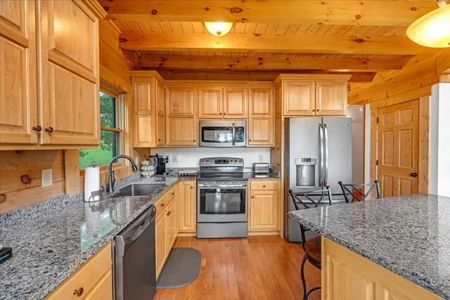 a kitchen with stainless steel appliances granite countertop a stove a sink and a refrigerator