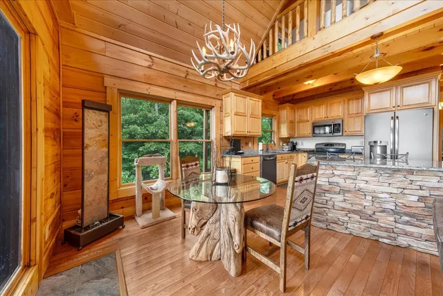 a view of a dining room with furniture a chandelier and wooden floor