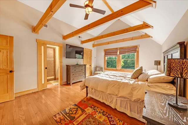 a bedroom with a bed and wooden floor