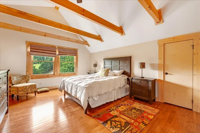 a bedroom with a bed and wooden floor