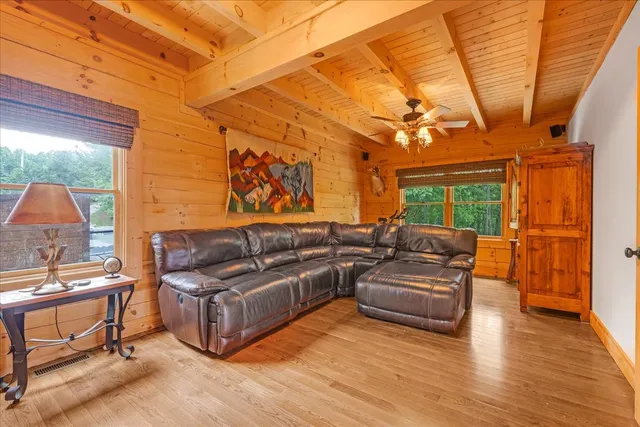 a living room with couches a flat screen tv and kitchen view